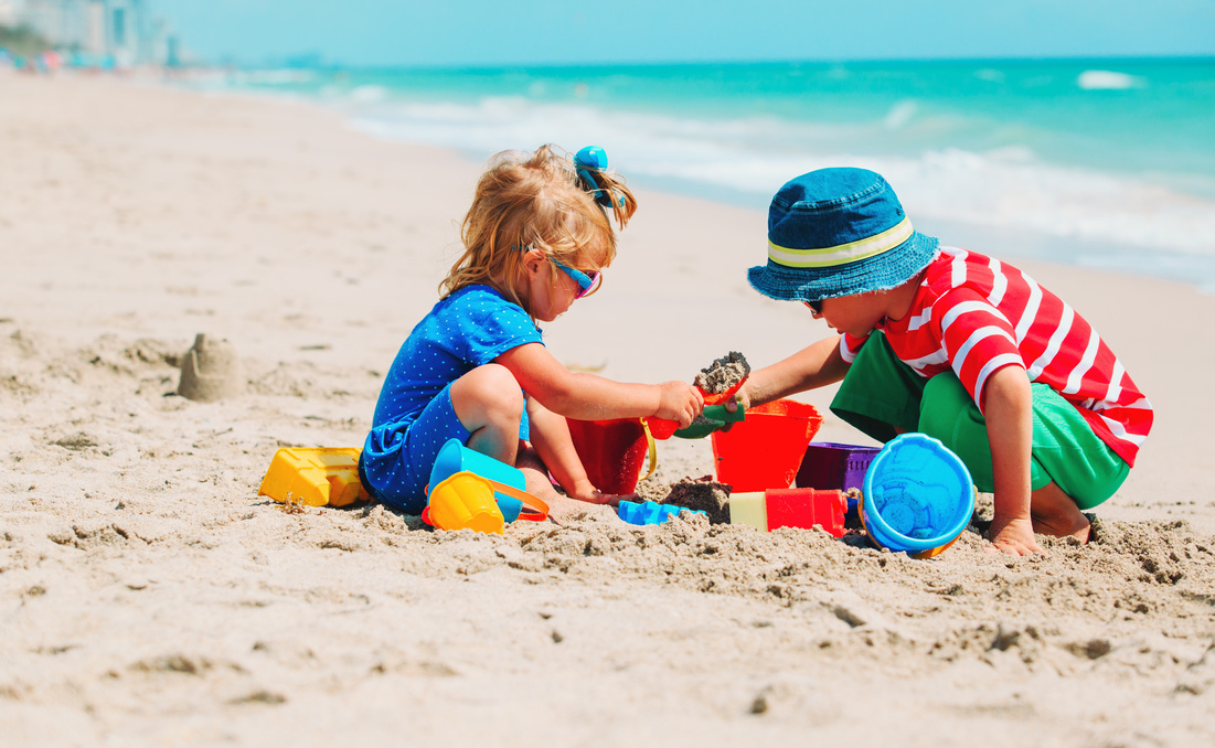 kids play with sand on summer beach